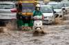 Commuters wade through water-logged road in Gurgaon as