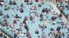 Spectators observe social distancing in the stands during
