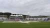 The pitch area is seen covered after rain stopped play on