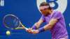 Rafael Nadal of Spain returns the ball to Ilya Ivashka of