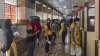 Beneficiaries wait in a queue to receive the COVID-19