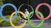 A man walks past the Olympic rings in Tokyo, Monday, June