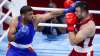 India's Satish Kumar, left, punches Uzbekistan's Bakhodir Jalolov 