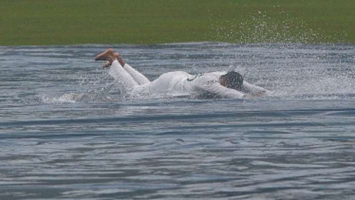 Bangladesh's Shakib Al Hasan slides on the plastic sheet covering the pitch after the play was calle